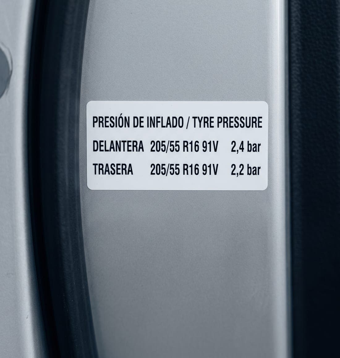 Etiqueta en el marco de la puerta del conductor con la medida 205/55 R16 91V y las presiones recomendadas para el eje delantero y el trasero