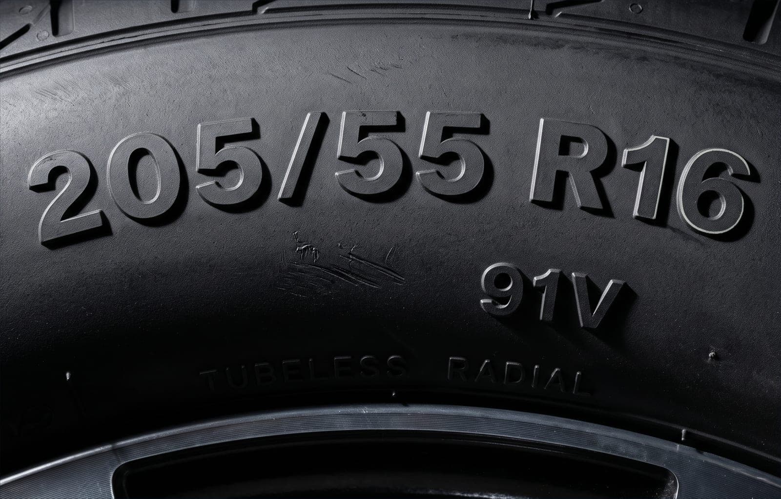 Flanco de un neumático con la medida 205/55 R16 91V grabada en relieve